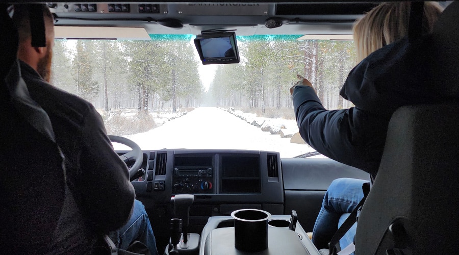 Two people looking through large windshield of an EarthCruiser EXP